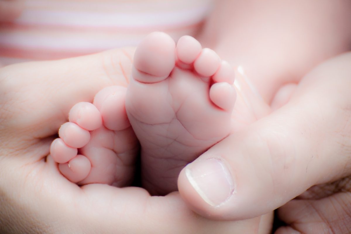 stopy dziecka w dłoniach dorosłego
