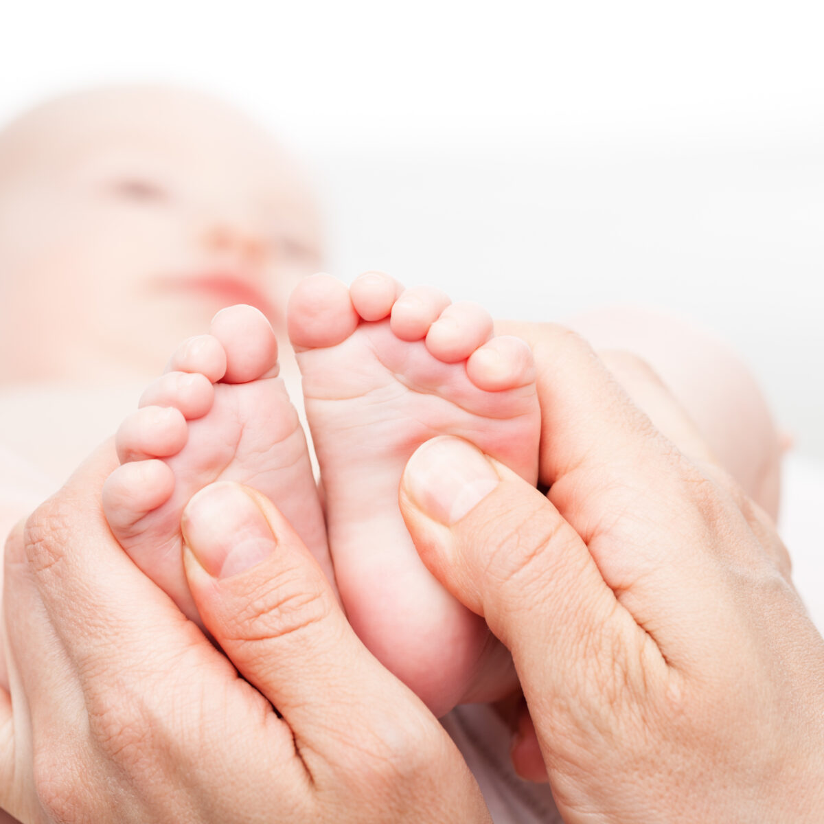 stopy noworodka w dłoniach dorosłej osoby